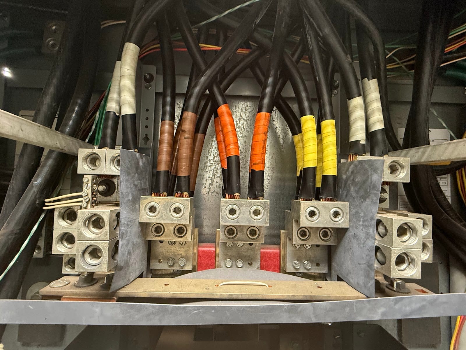 Phase-taped feeder cables terminated on lugs inside commercial switchgear serviced by Lightning Bay Electric in Tampa, FL