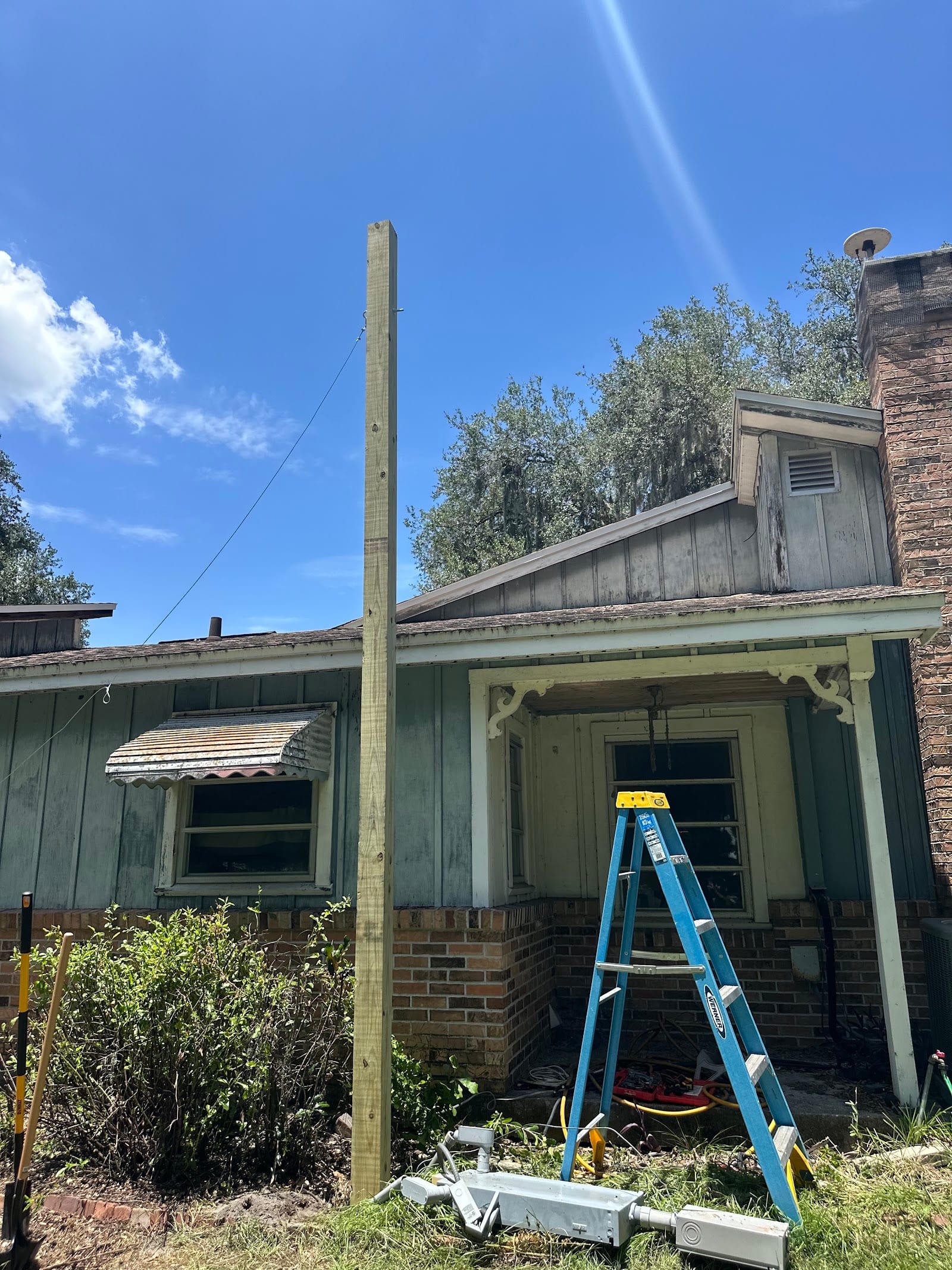 New pressure-treated service pole and guy wire set by Lightning Bay Electric during an overhead electrical service replacement at an older Tampa Bay home