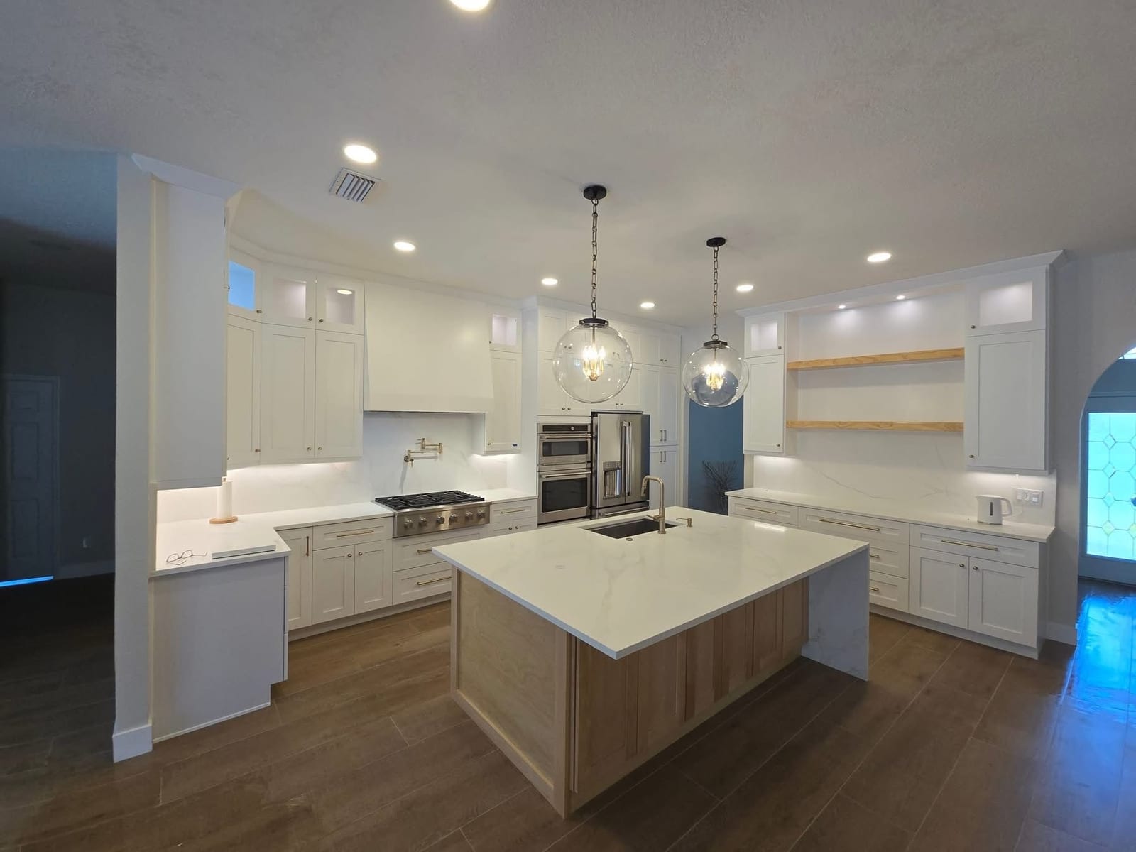 Kitchen island with three black pendant lights and a lantern fixture installed by Lightning Bay Electric during a remodel in Brandon, FL