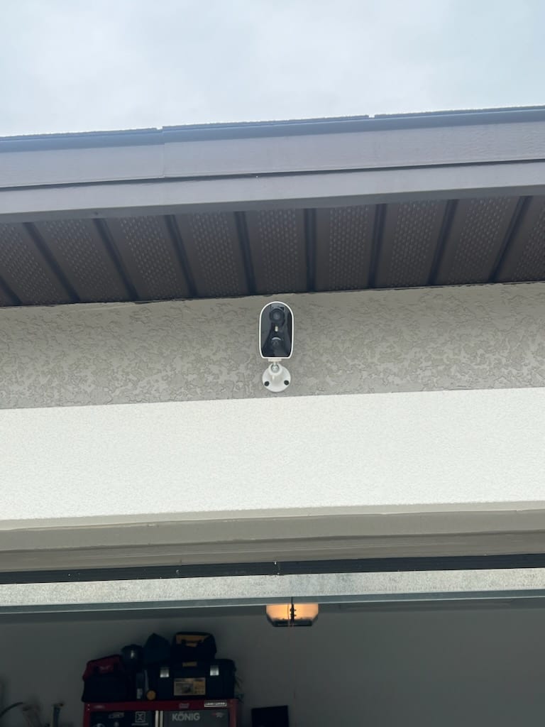 Outdoor security camera mounted at the garage soffit with concealed wiring by Lightning Bay Electric at a Tampa Bay home