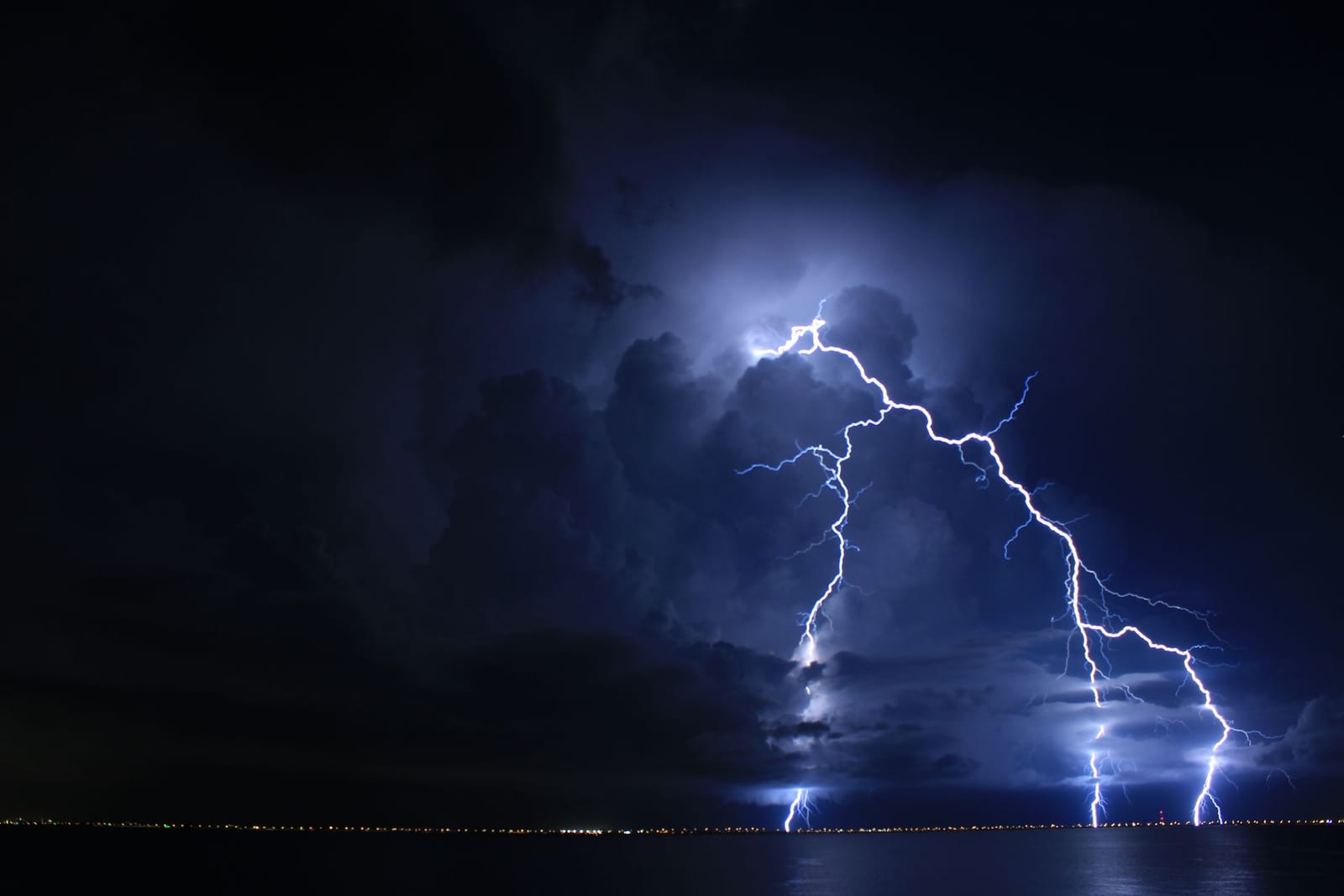 Lightning strikes over Tampa Bay at night, the reason Lightning Bay Electric recommends whole-home surge protection for every Florida home